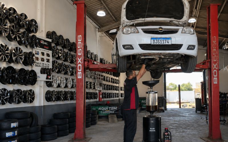 Mecânico realizando troca de óleo no motor do carro